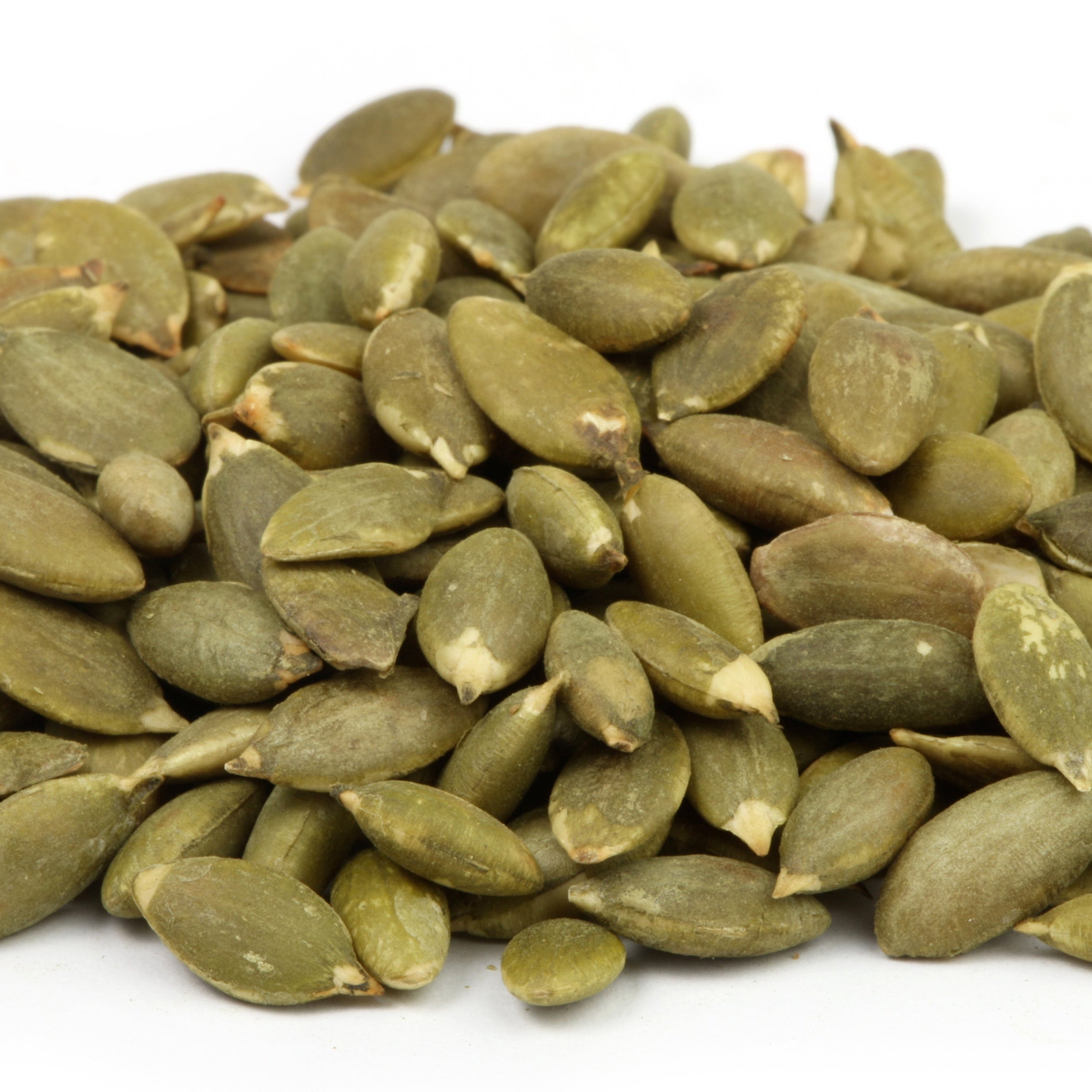 Pile of green pumpkin seeds on a white background